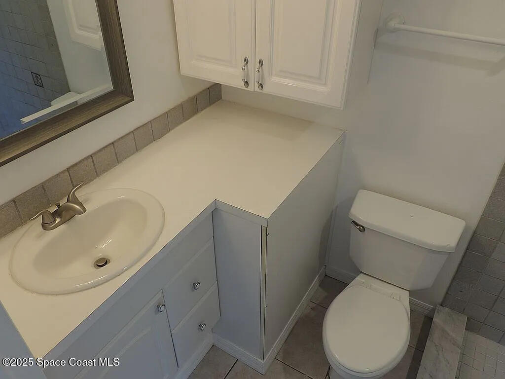 206 4th Avenue Indialantic, FL 32903 - Photo 31 of 43 a white toilet sitting next to a bathroom sink