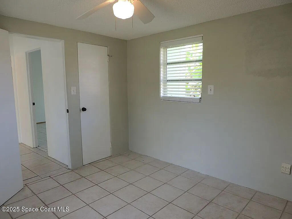 206 4th Avenue Indialantic, FL 32903 - Photo 42 of 43 a view of an empty room with window and chandelier fan