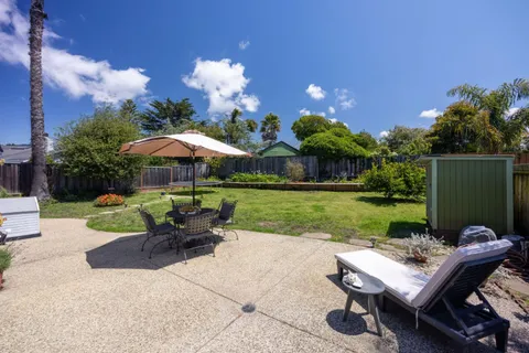 a view of a house with backyard sitting area and garden