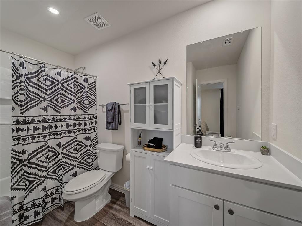 921 West 9th Street Bonham, TX 75418 - Photo 10 of 22 Primary Ensuite Full bathroom featuring vanity and dark wood-type flooring