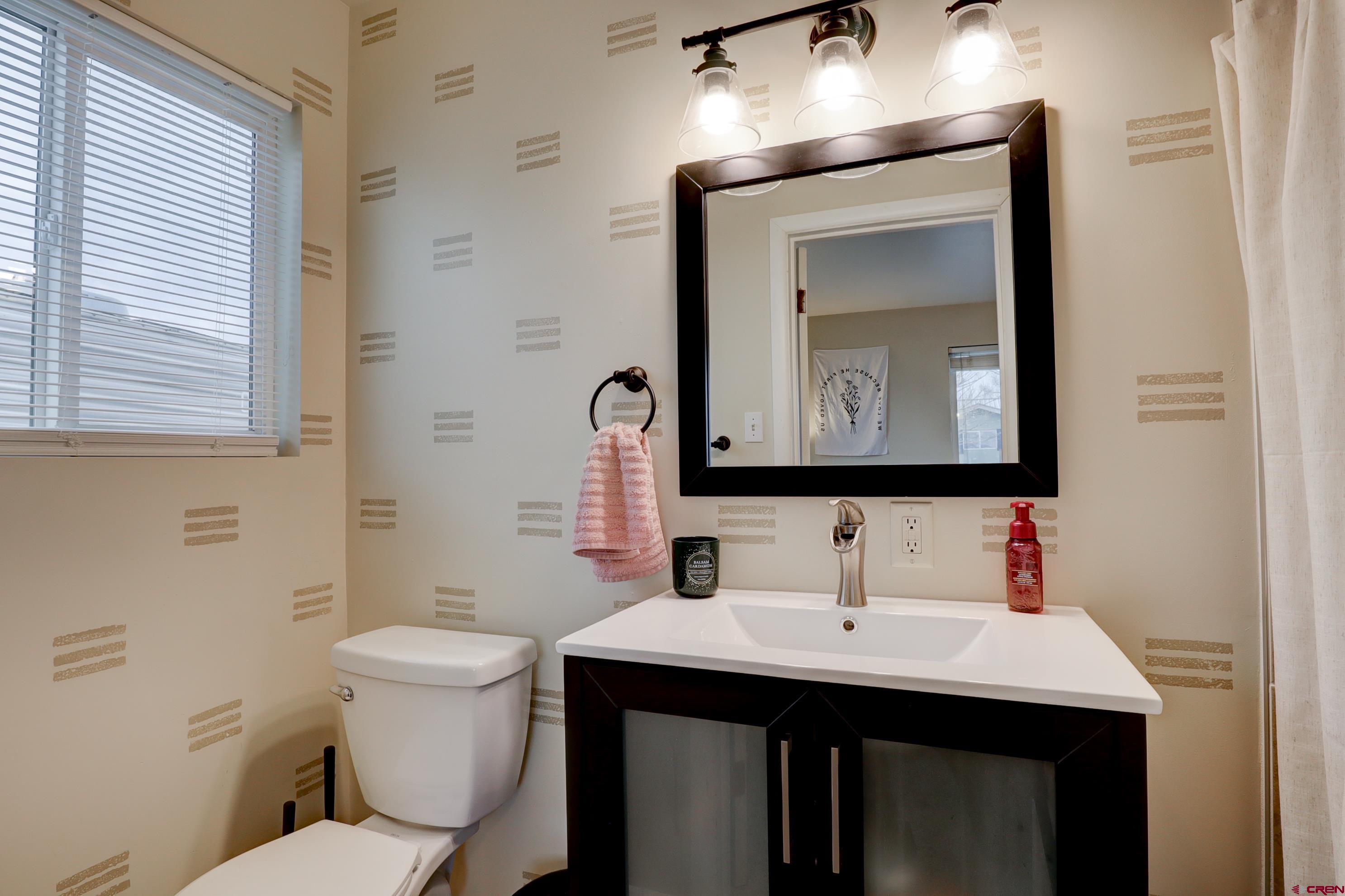 2019 Rolling Road Cortez, CO 81321 - Photo 15 of 35 a bathroom with a toilet sink and mirror
