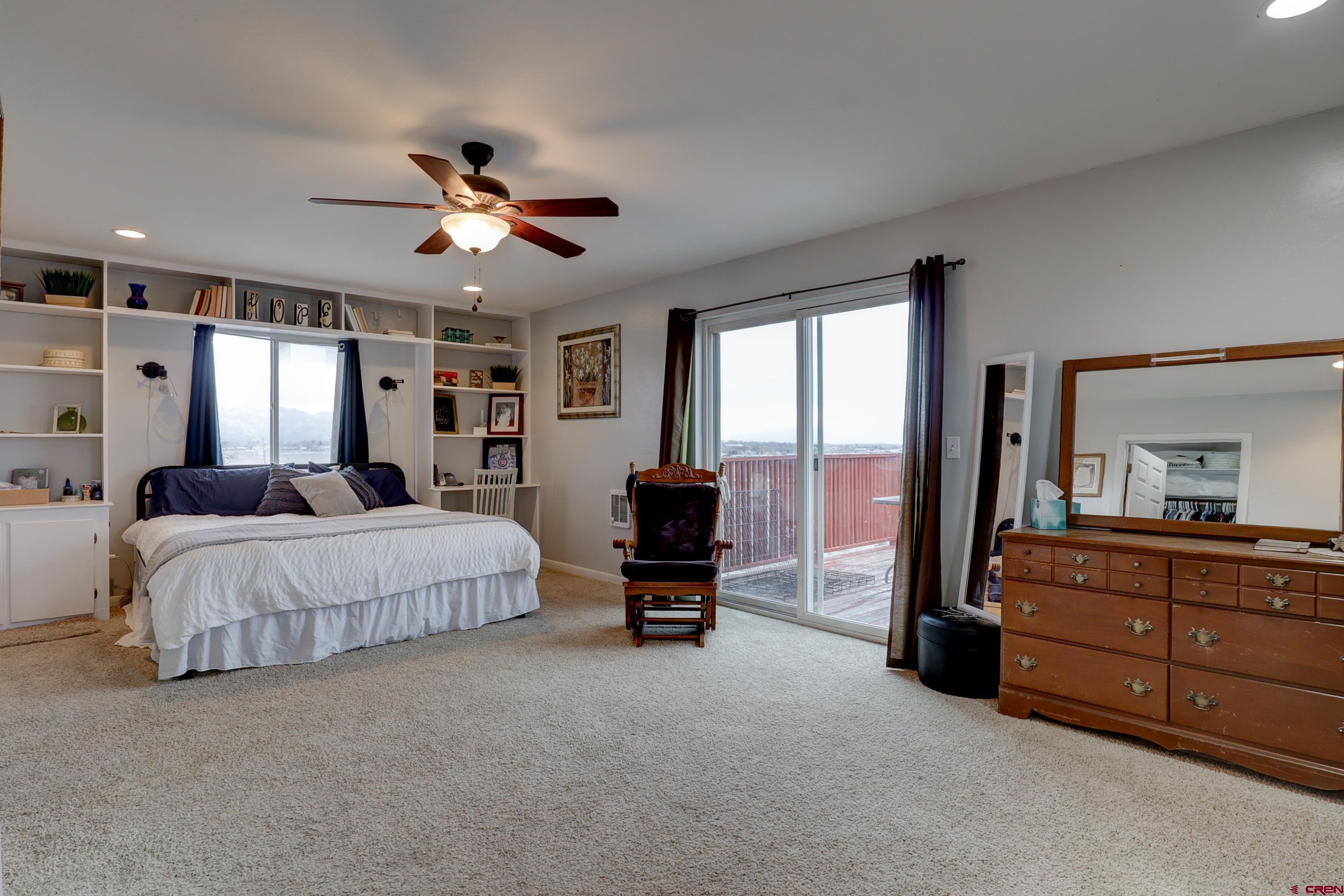 2019 Rolling Road Cortez, CO 81321 - Photo 20 of 35 a spacious bedroom with a bed and a chandelier