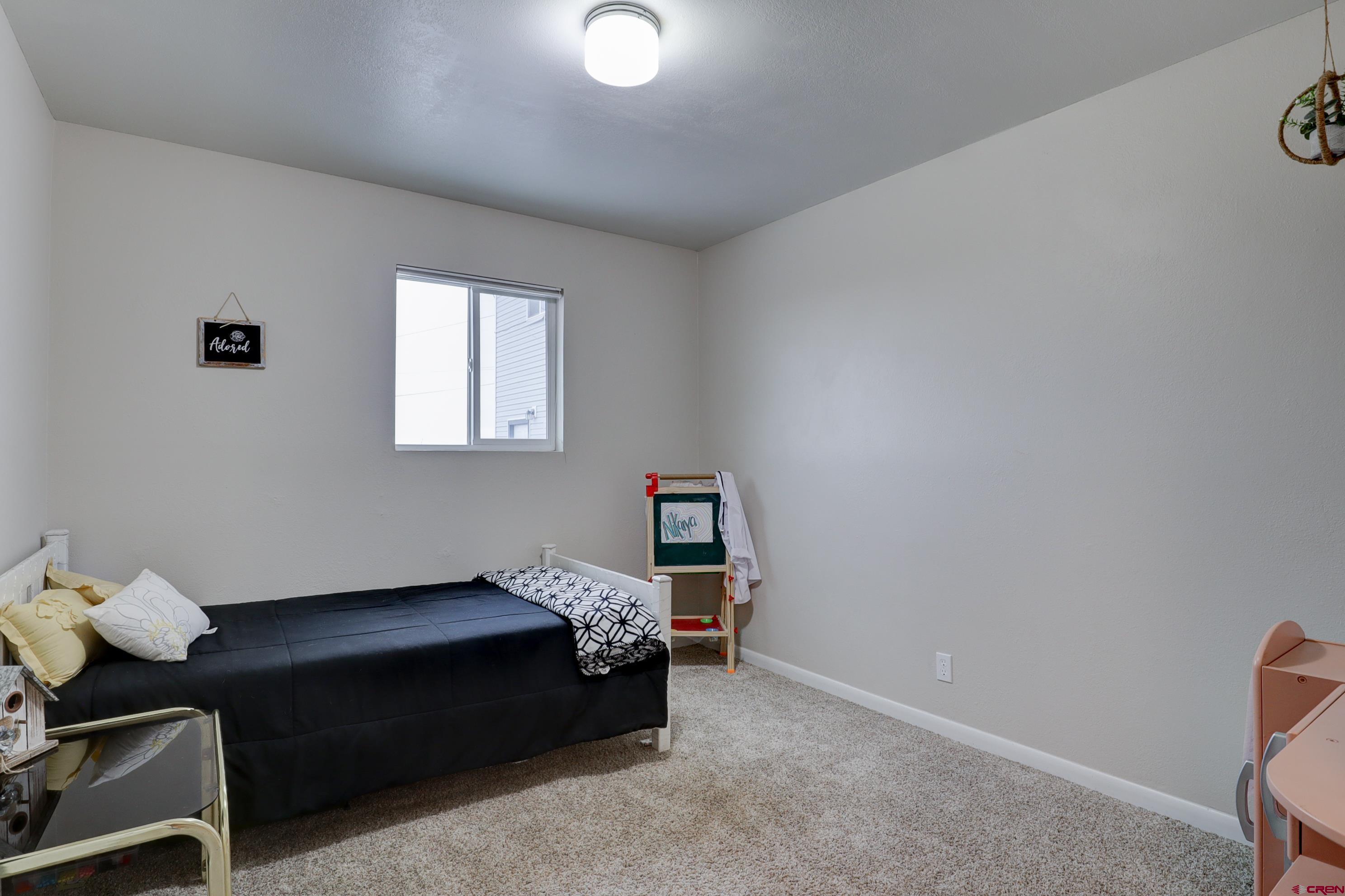 2019 Rolling Road Cortez, CO 81321 - Photo 8 of 35 a bedroom with a bed and window