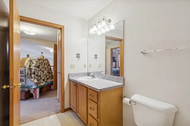 a bathroom with a granite countertop sink a toilet and a mirror