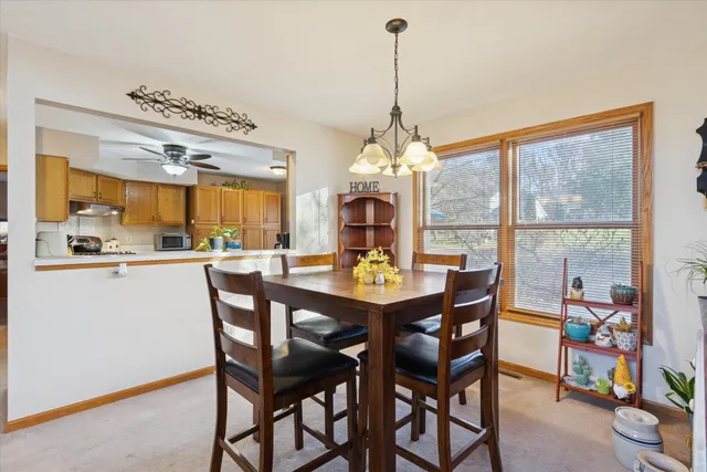 a view of a dining room and livingroom with furniture large windows a chandelier