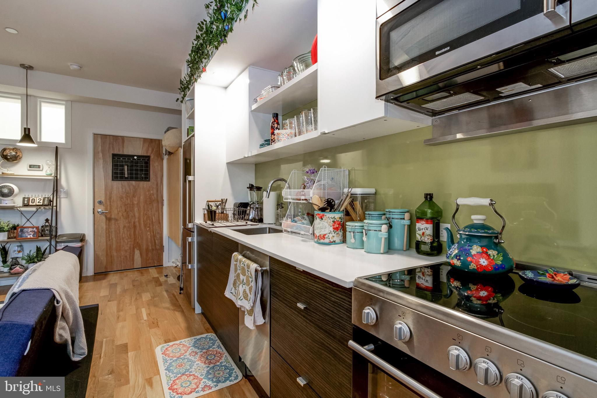 1942 North Front Street, Unit 208 Philadelphia, PA 19122 - Photo 3 of 10 a kitchen with kitchen island a sink stove and cabinets