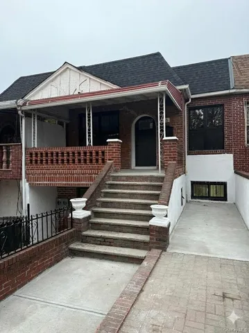 a view of a house with large windows and a small yard