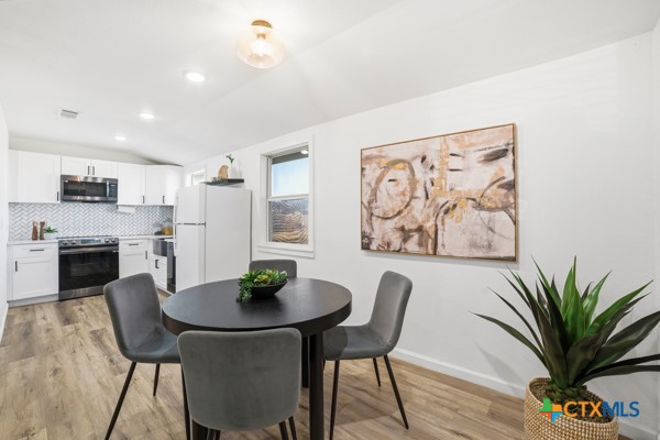 3267 Dairy Road Temple, TX 76501 - Photo 16 of 42 a view of a dining room with furniture and wooden floor
