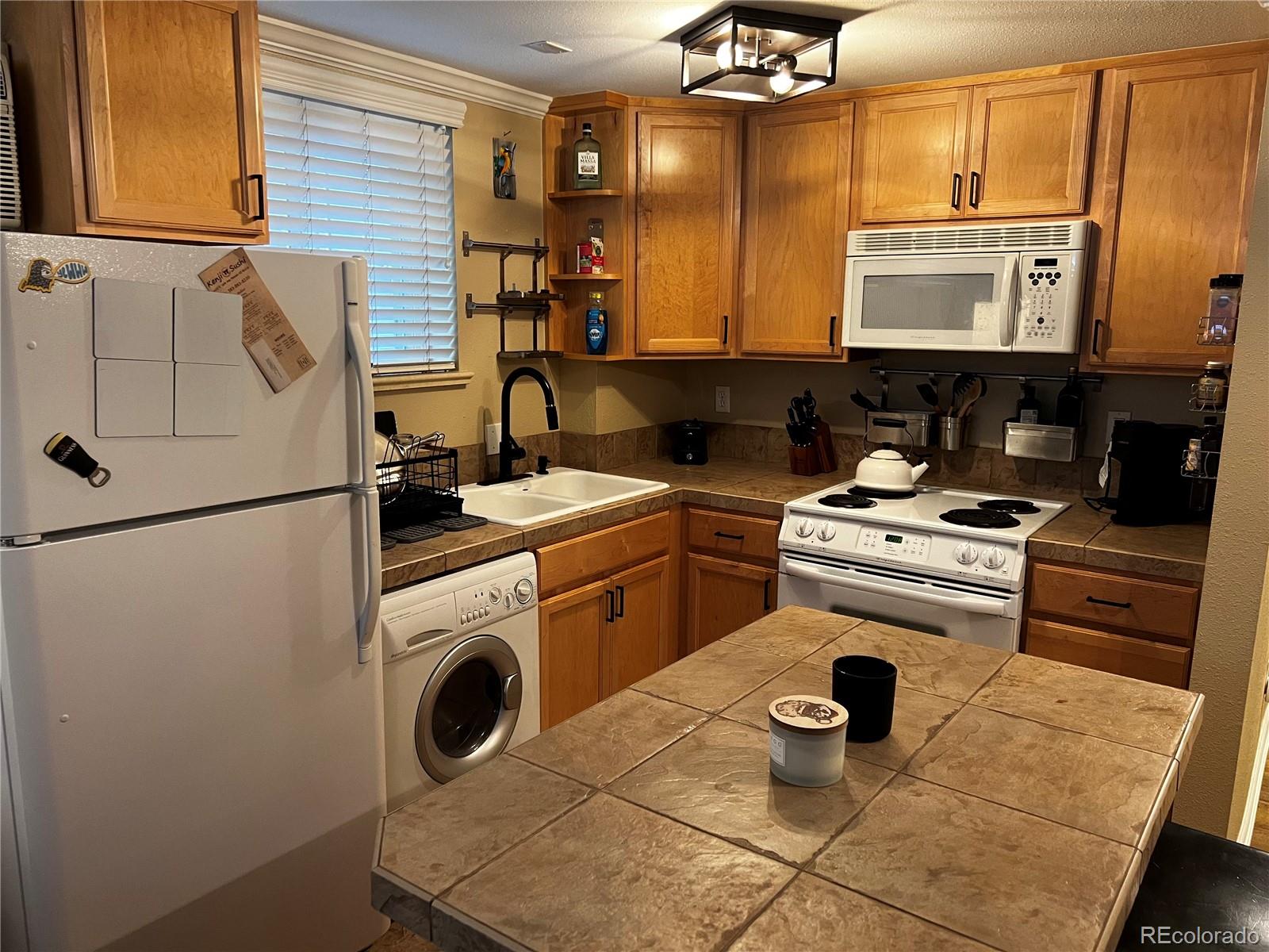 1260 North Humboldt Street, Unit 3 Denver, CO 80218 - Photo 4 of 6 a kitchen with a stove a sink and a refrigerator