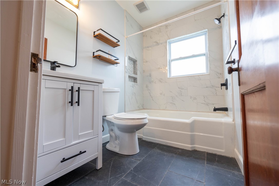 14474 Pease Road Maple Heights, OH 44137 - Photo 14 of 50 Full bathroom featuring tiled shower / bath, toilet, tile flooring, and vanity