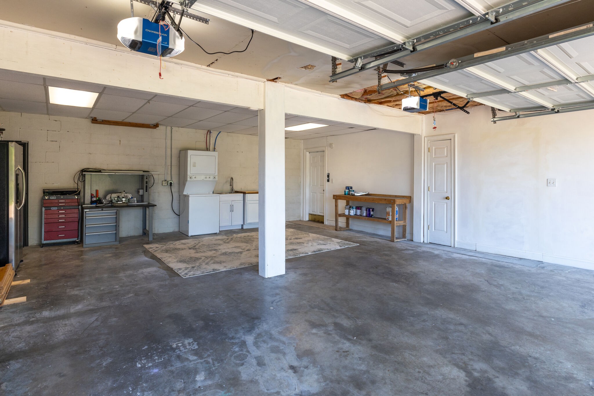 6179 Pettus Road Antioch, TN 37013 - Photo 46 of 57 HUGE Garage for the cars and more. Frig #3 on the far left. Washer/dryer set/utility sink with extra cabinet remain. Door in the back right corner is to the downstairs rec room. Door on the right to storage under the stairs. New garage door openers.