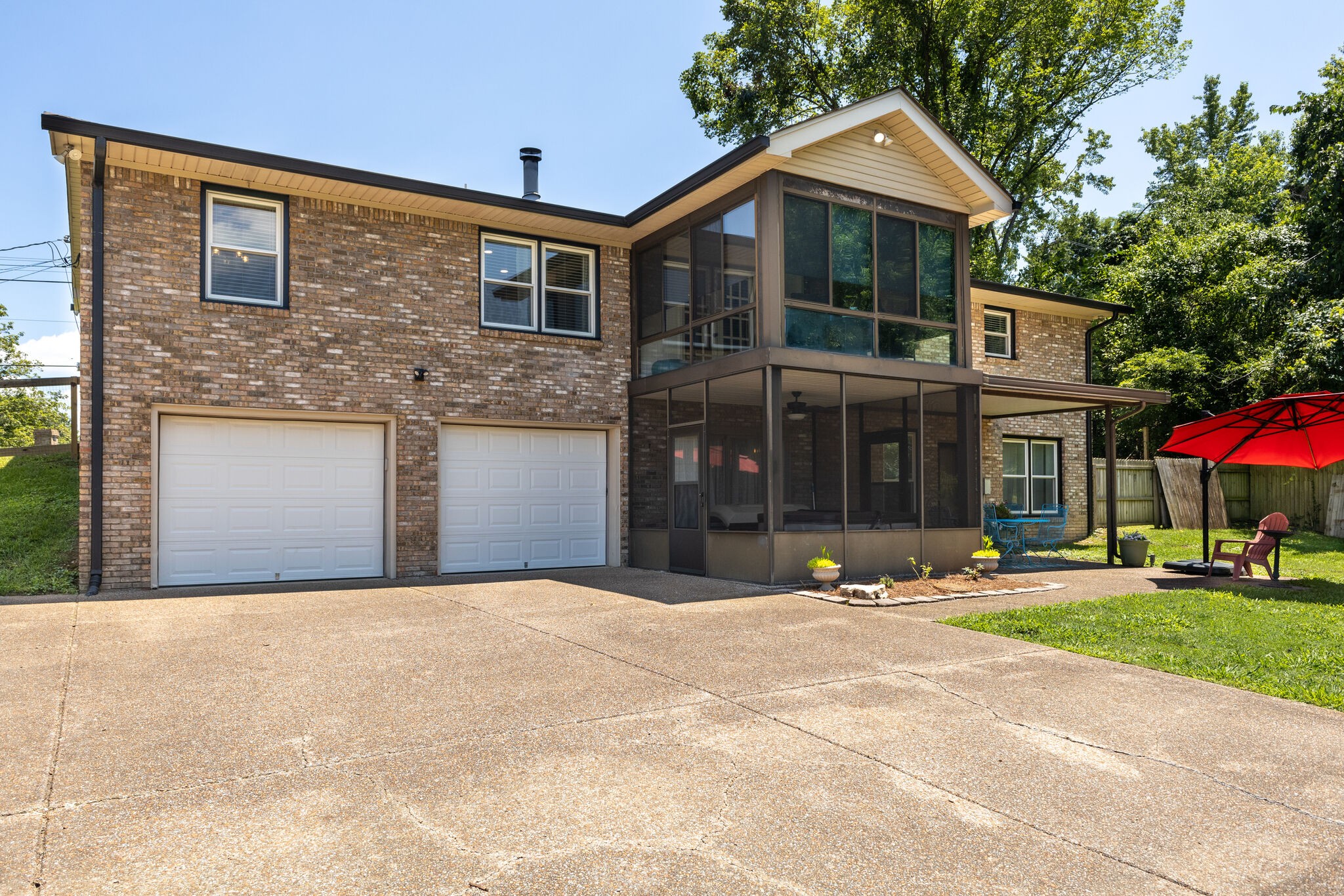 6179 Pettus Road Antioch, TN 37013 - Photo 6 of 57 Generous aggregate parking pad with double garage and new garage door openers. Keypad, too. Double sunroom. Lower sunroom has a hot tub and a tanning bed that remain. Covered patio to the far right.