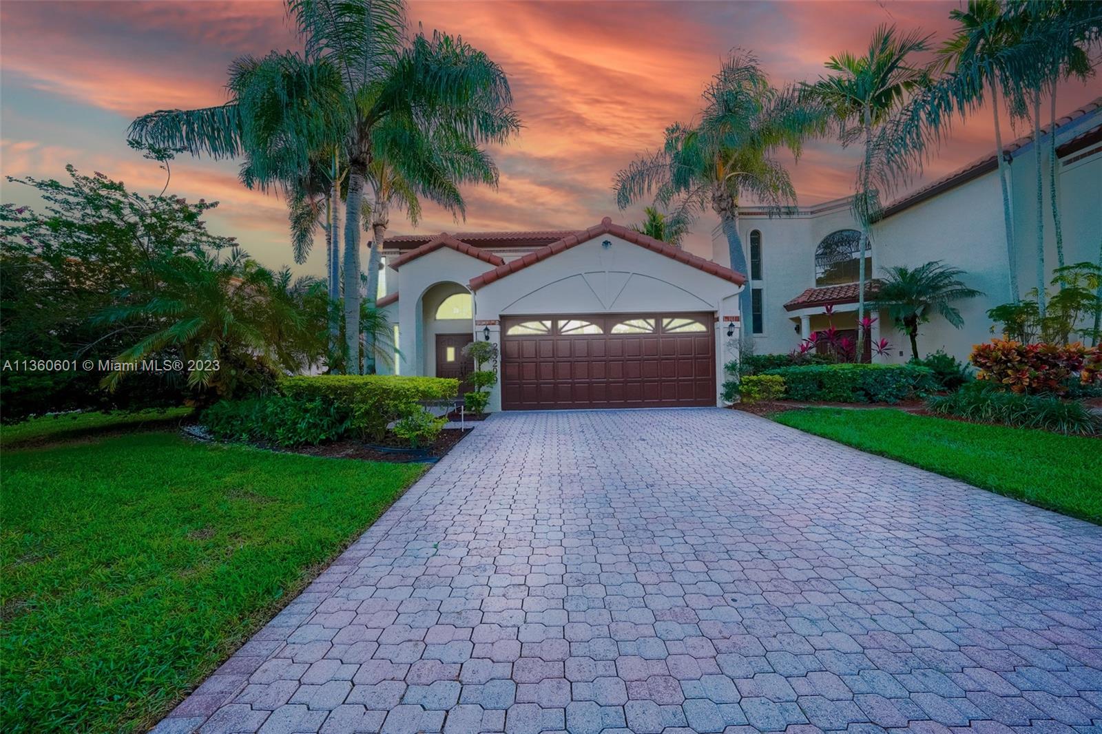 23299 Mirabella Circle North Boca Raton, FL 33433 - Photo 5 of 30 a front view of a house with a garden and palm trees
