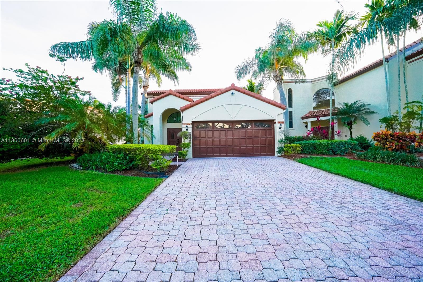 23299 Mirabella Circle North Boca Raton, FL 33433 - Photo 6 of 30 a front view of a house with a garden and palm trees