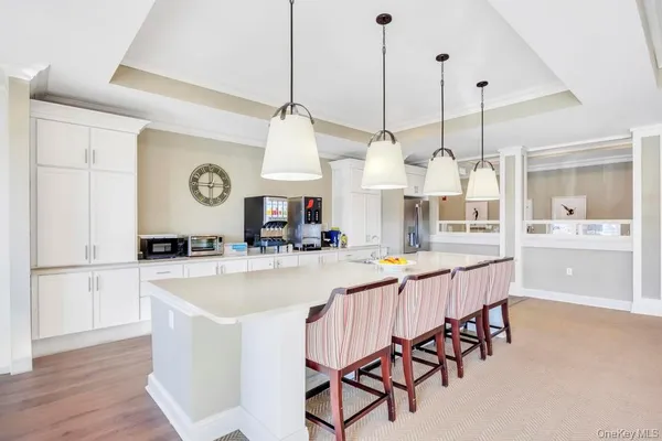 a large kitchen with kitchen island stainless steel appliances a table chairs and a chandelier