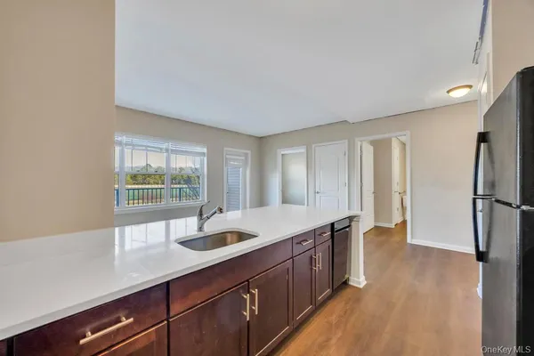 a kitchen with stainless steel appliances granite countertop a sink a refrigerator and wooden cabinets