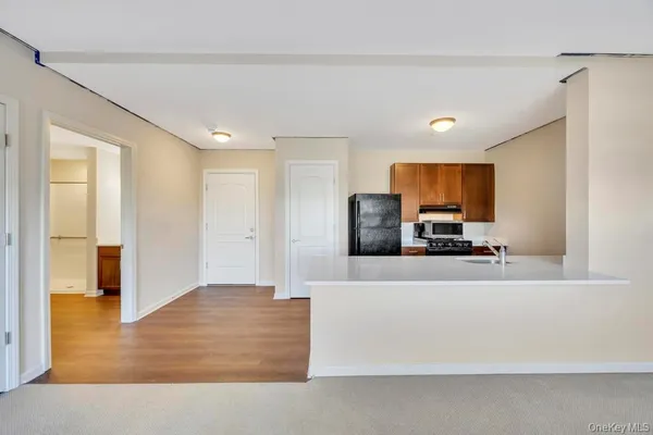 a large white kitchen with cabinets and a wooden floor