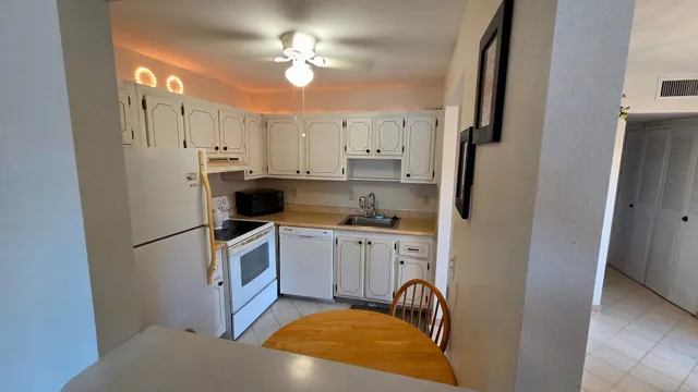 a kitchen with stainless steel appliances a refrigerator a stove a sink dishwasher and a refrigerator with wooden floor