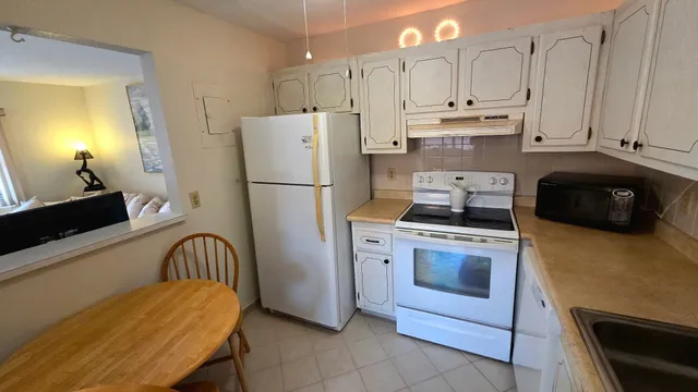 a kitchen with stainless steel appliances white cabinets and a refrigerator
