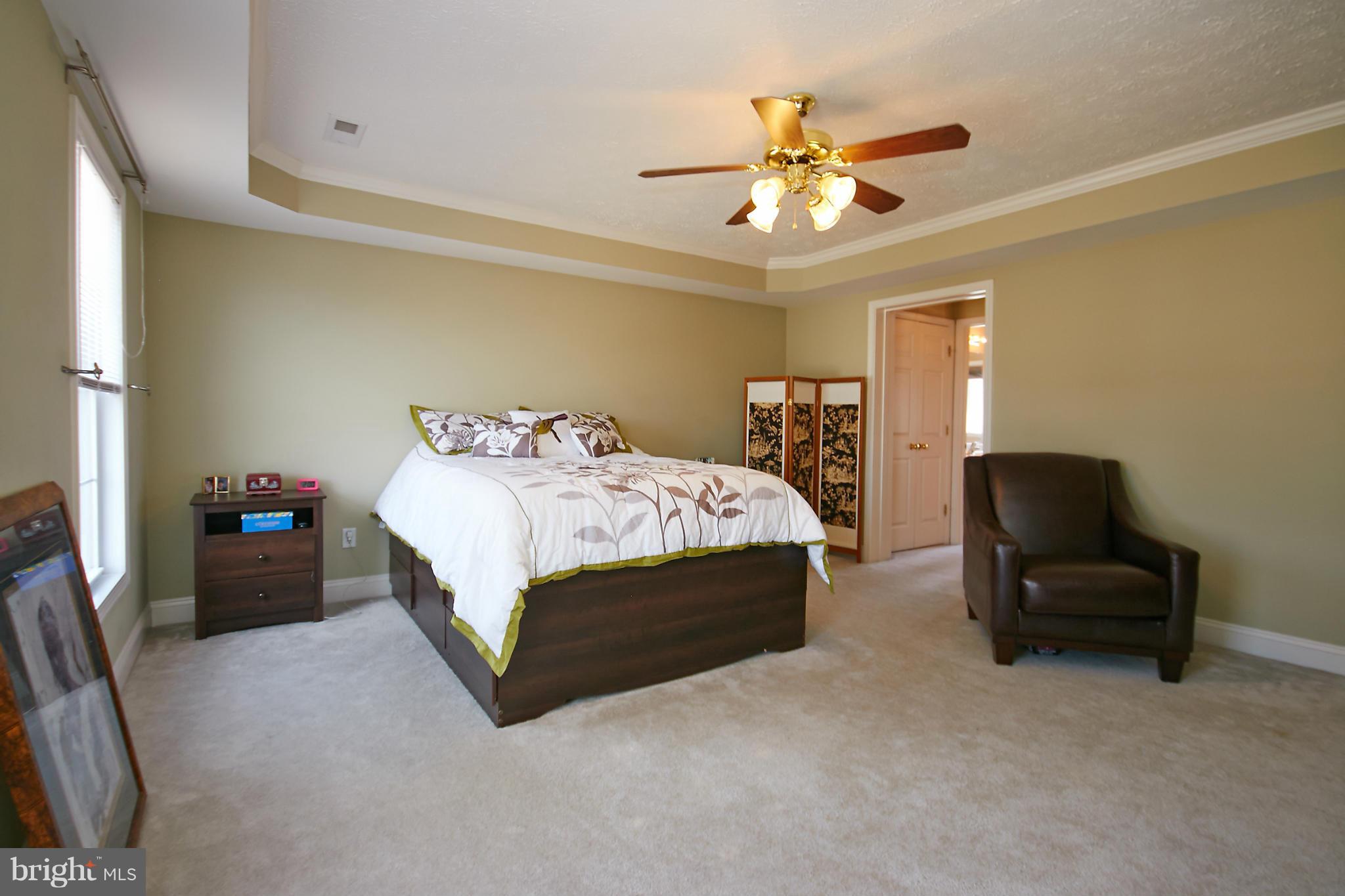 4 Yosemite Ridge Court Stafford, VA 22554 - Photo 15 of 26 a bedroom with a bed couch and a ceiling fan