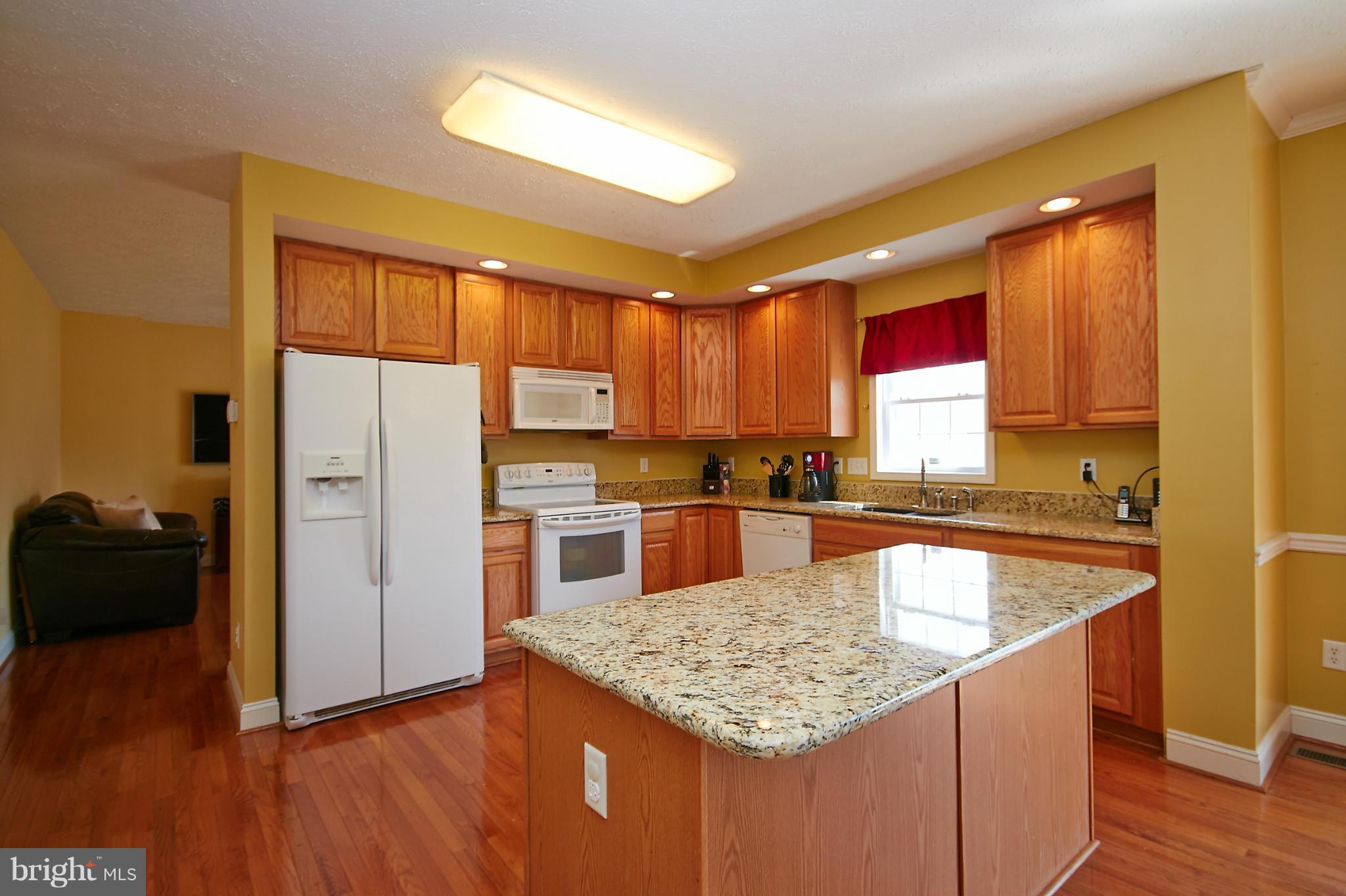 4 Yosemite Ridge Court Stafford, VA 22554 - Photo 7 of 26 a kitchen with stainless steel appliances granite countertop a refrigerator a sink dishwasher a stove with wooden cabinets and floor