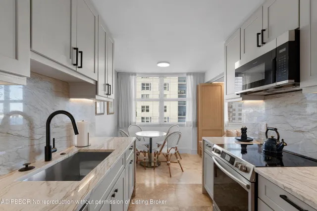 a kitchen with stainless steel appliances a sink dishwasher a refrigerator and cabinets