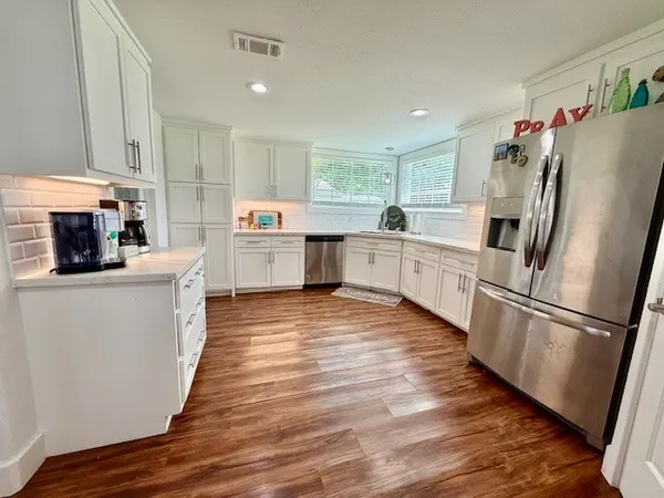 a kitchen with granite countertop a table chairs stove and cabinets