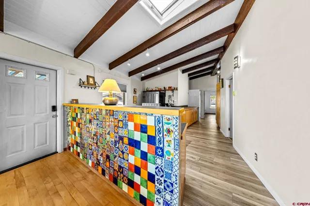 a hallway with painting on the wall and a potted plant