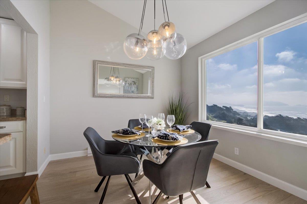 5007 Palmetto Avenue, Unit 42 Pacifica, CA 94044 - Photo 15 of 53 a dining room with furniture a large window and a chandelier