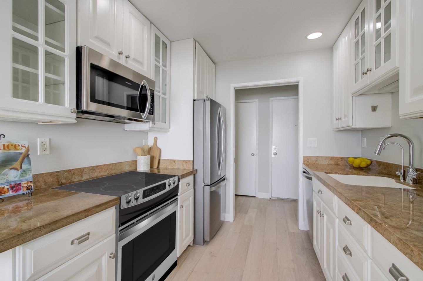 5007 Palmetto Avenue, Unit 42 Pacifica, CA 94044 - Photo 20 of 53 a kitchen with stainless steel appliances granite countertop a sink stove microwave and refrigerator