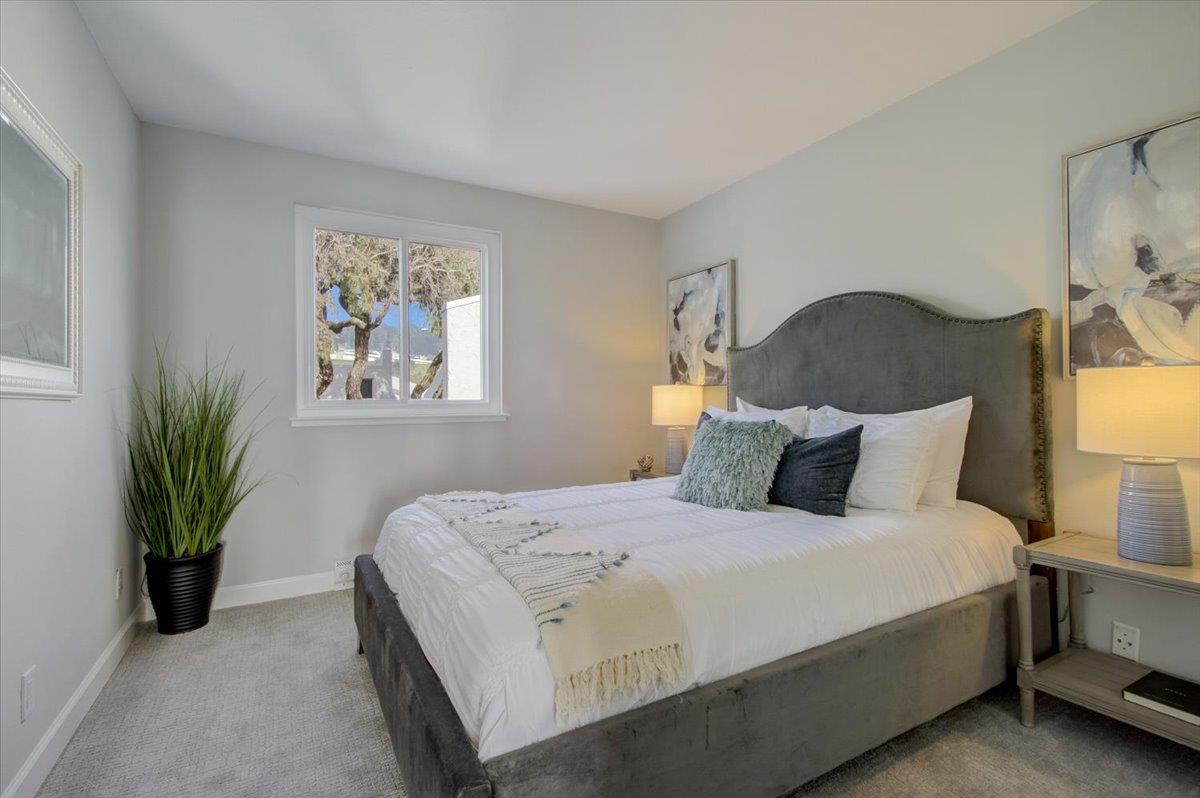 5007 Palmetto Avenue, Unit 42 Pacifica, CA 94044 - Photo 22 of 53 a bedroom with a large bed and a potted plant
