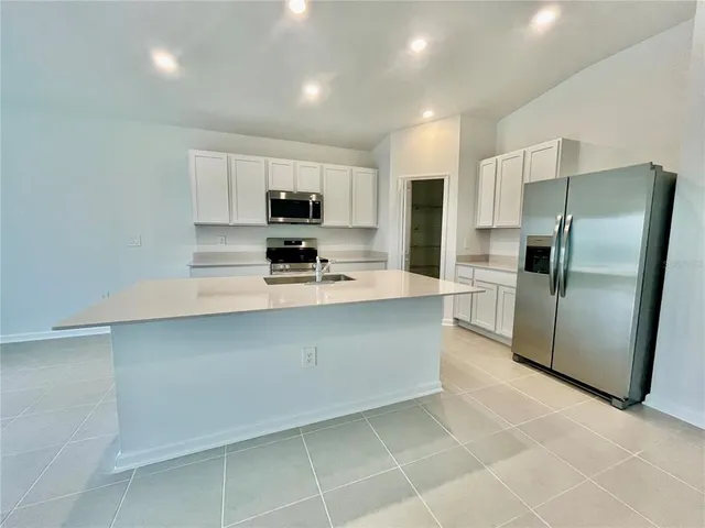 a kitchen with stainless steel appliances a refrigerator sink microwave and cabinets