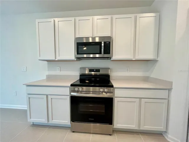 a kitchen with white cabinets and stainless steel appliances