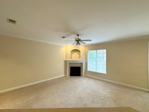an empty room with windows and fireplace