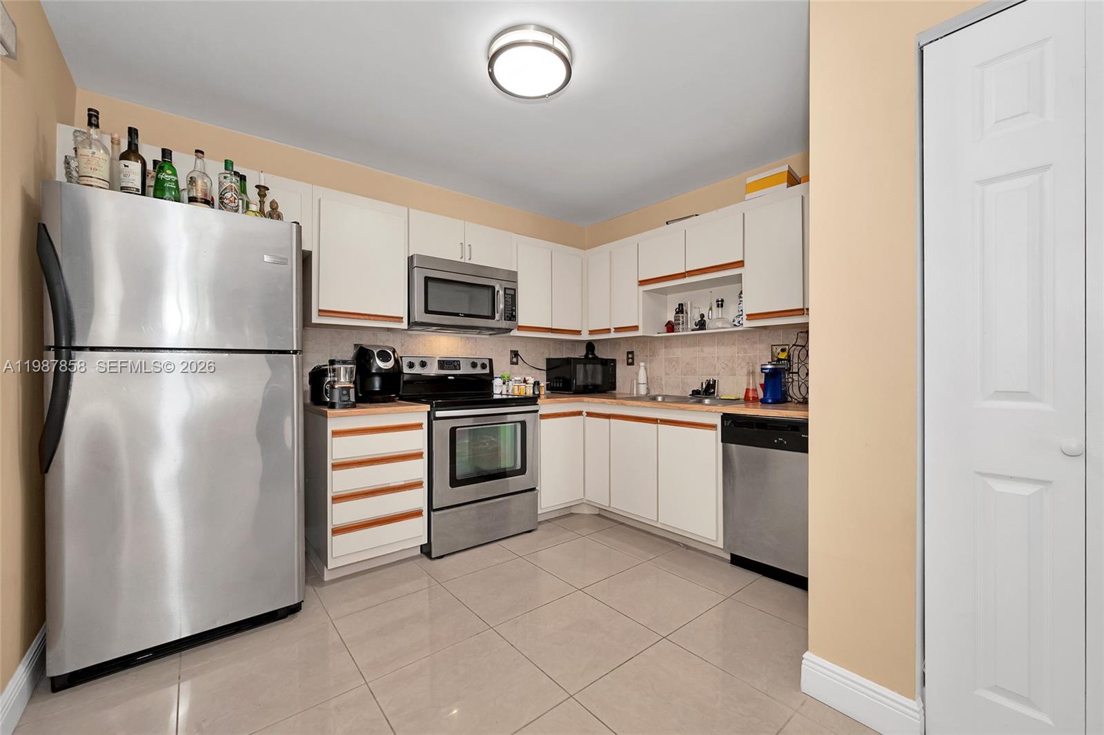 10441 Mahogany Key Circle, Unit 101 Miami, FL 33196 - Photo 11 of 26 a kitchen with cabinets stainless steel appliances and a refrigerator