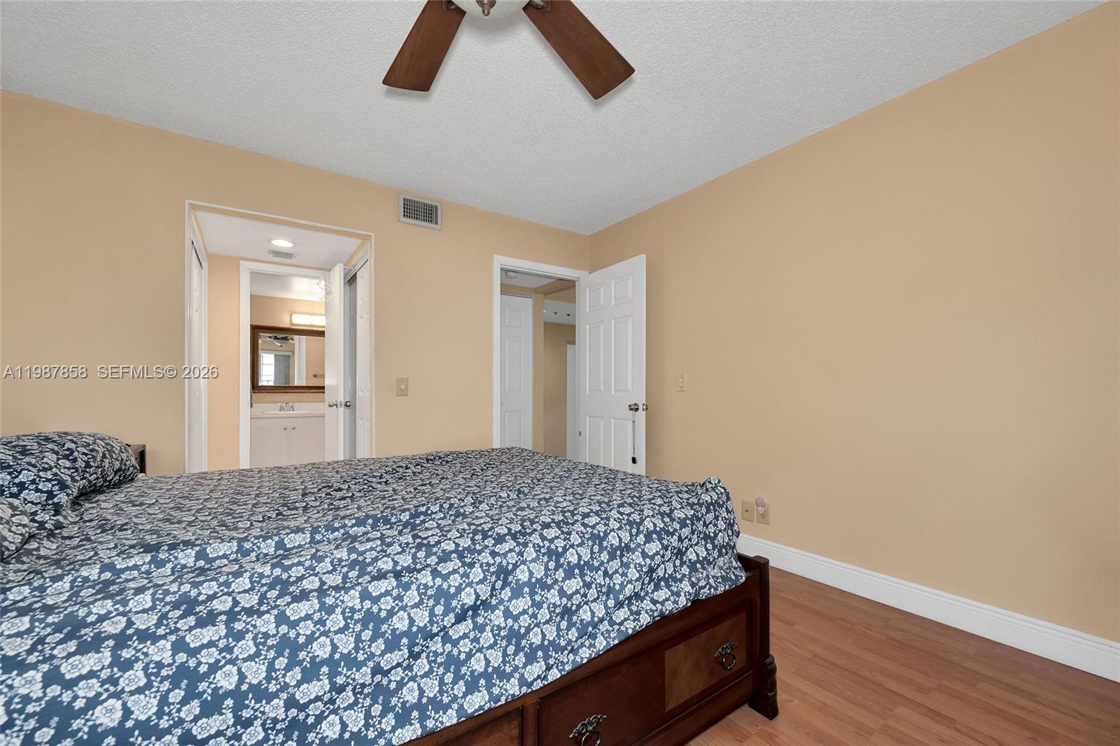 10441 Mahogany Key Circle, Unit 101 Miami, FL 33196 - Photo 14 of 26 a bedroom with a bed and wooden floor