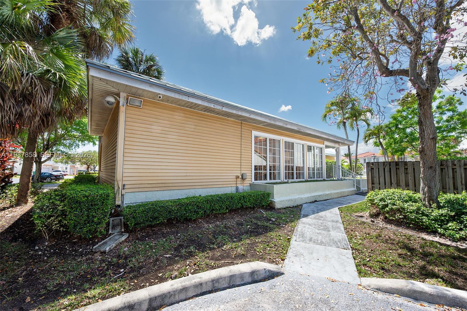10441 Mahogany Key Circle, Unit 101 Miami, FL 33196 - Photo 26 of 26 a view of a house with a small yard and a large tree