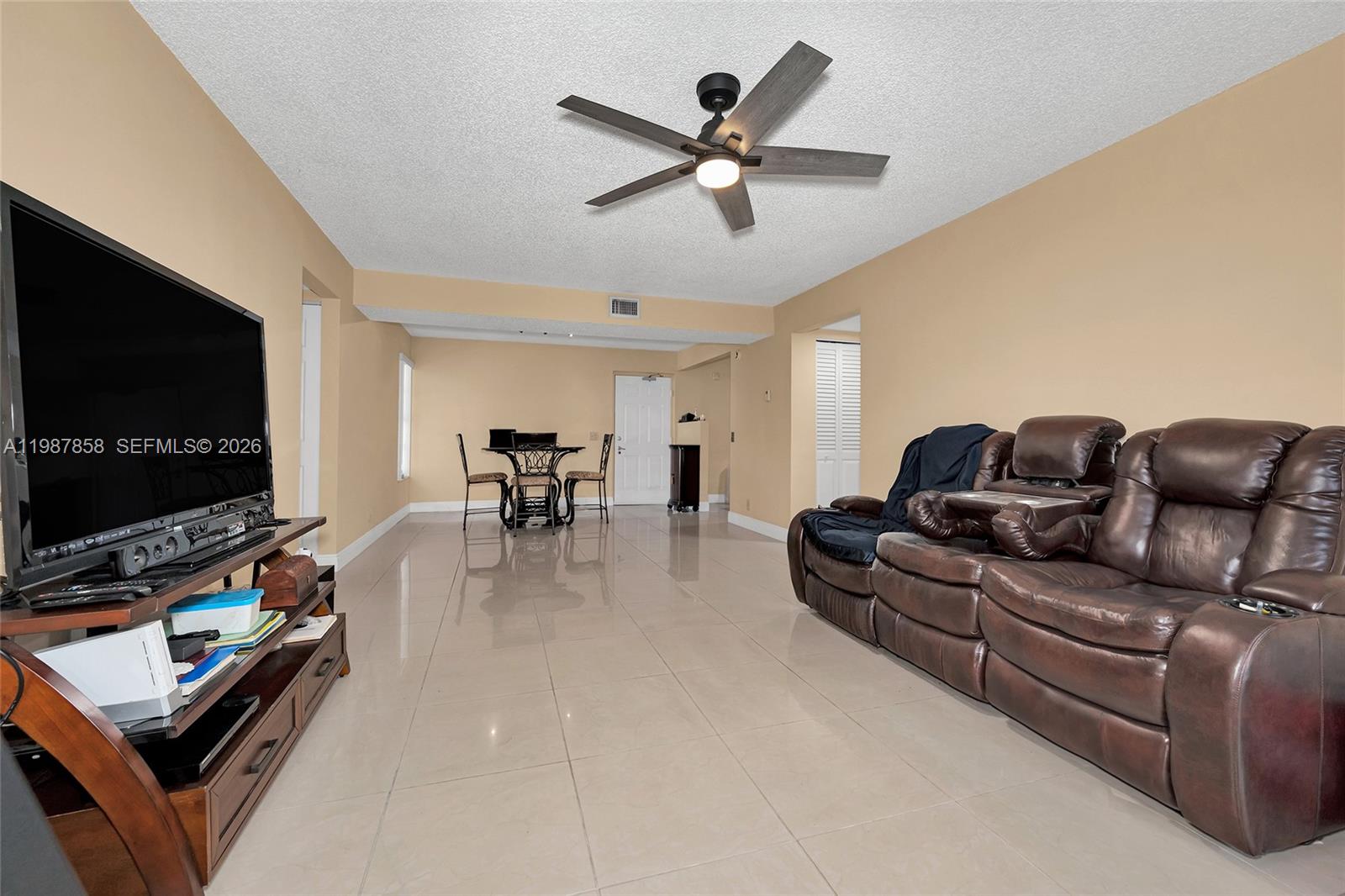 10441 Mahogany Key Circle, Unit 101 Miami, FL 33196 - Photo 9 of 26 a living room with furniture and a flat screen tv with wooden floor