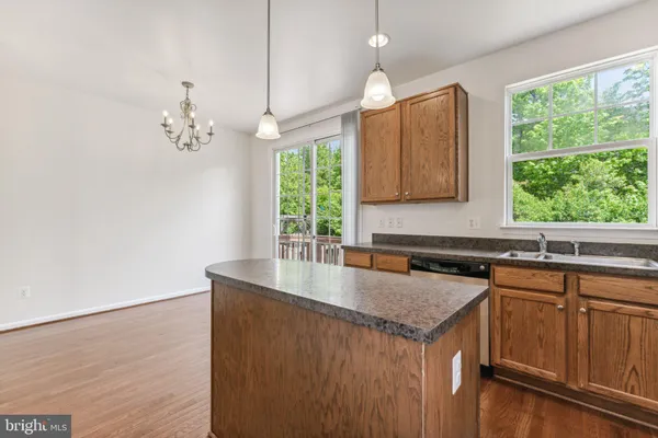a kitchen with a stove a sink a counter space and a window