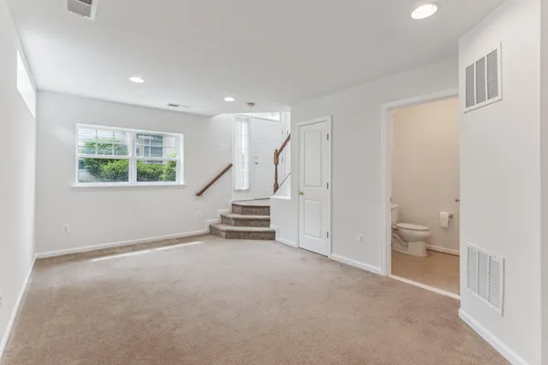 a view of an empty room with a window and a bathroom