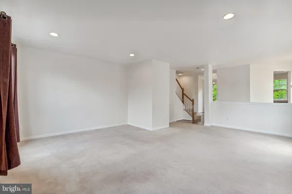 an empty room with a ceiling fan and windows