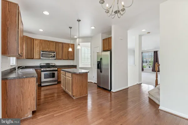a kitchen with stainless steel appliances granite countertop a refrigerator a stove a sink and a oven
