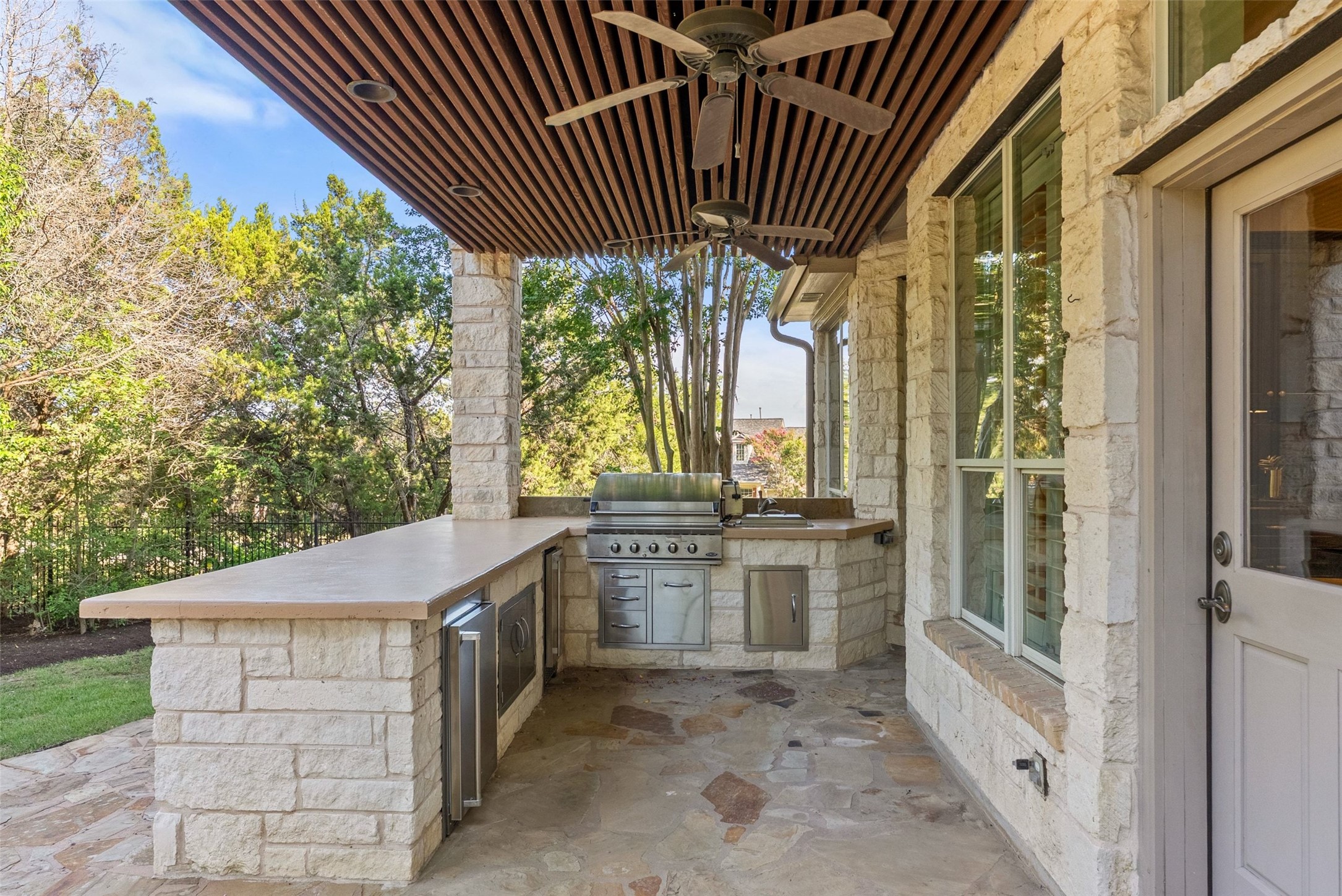 8215 Dark Ridge Cove Austin, TX 78737 - Photo 34 of 40 An inviting large patio features a covered outdoor kitchen with a built-in grill.
