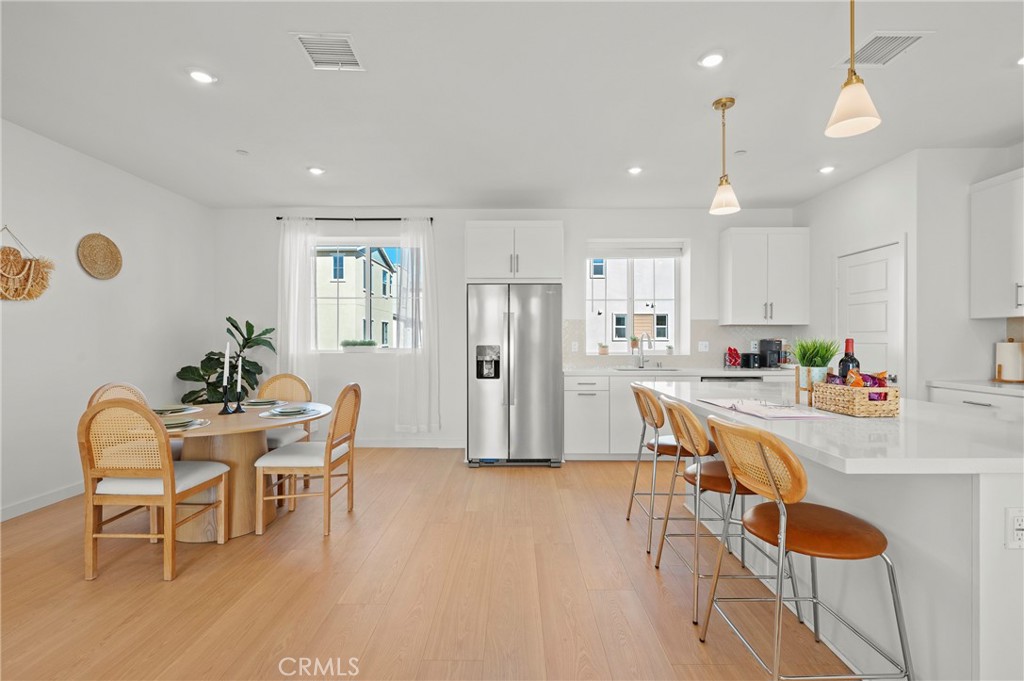 131 Ruby Road Rancho Mission Viejo, CA 92694 - Photo 12 of 65 a kitchen with stainless steel appliances granite countertop a dining table chairs refrigerator sink and cabinets