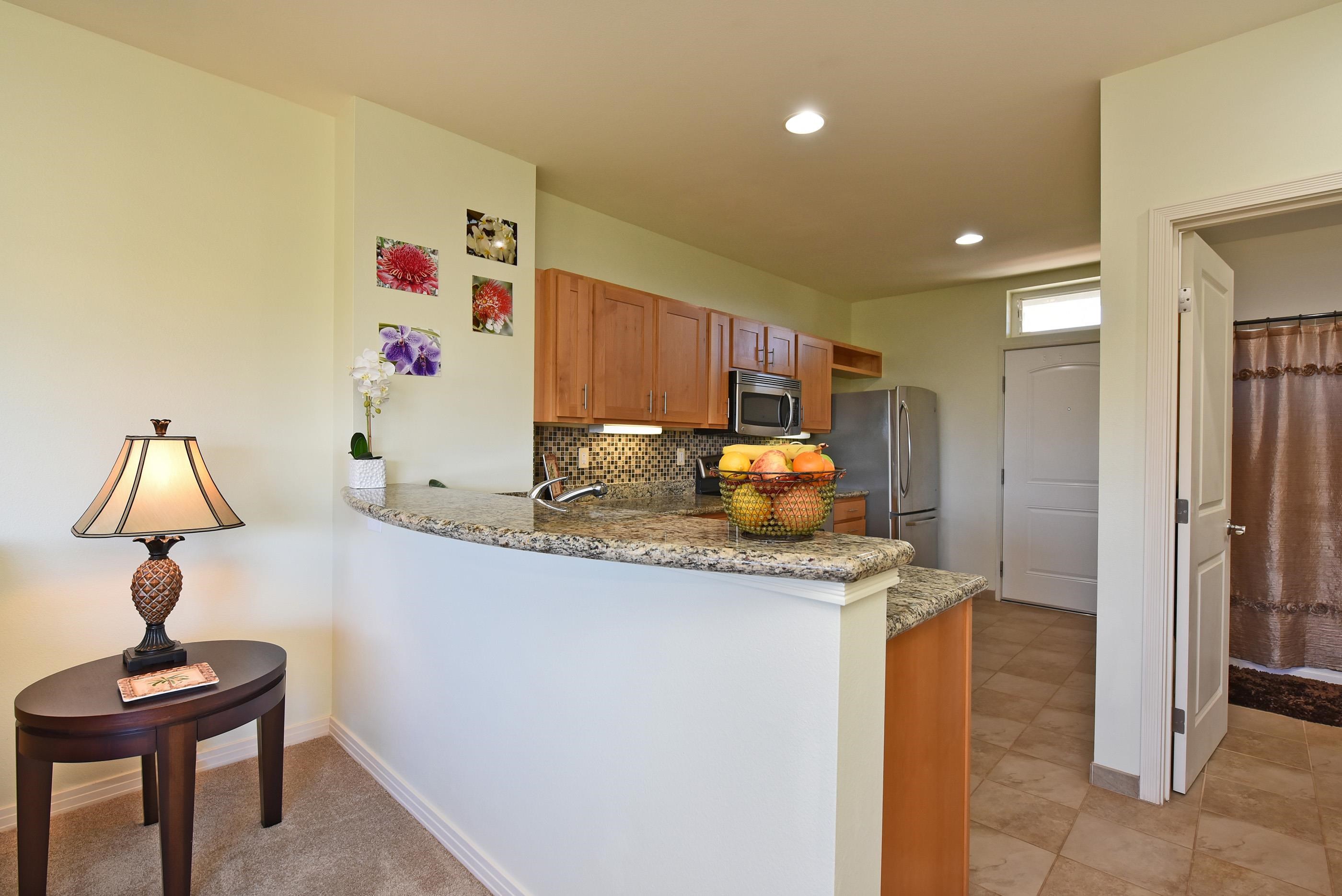 3708 Lower Honoapiilani Road, Unit E30 Lahaina, HI 96761 - Photo 16 of 30 a kitchen with granite countertop cabinets and refrigerator