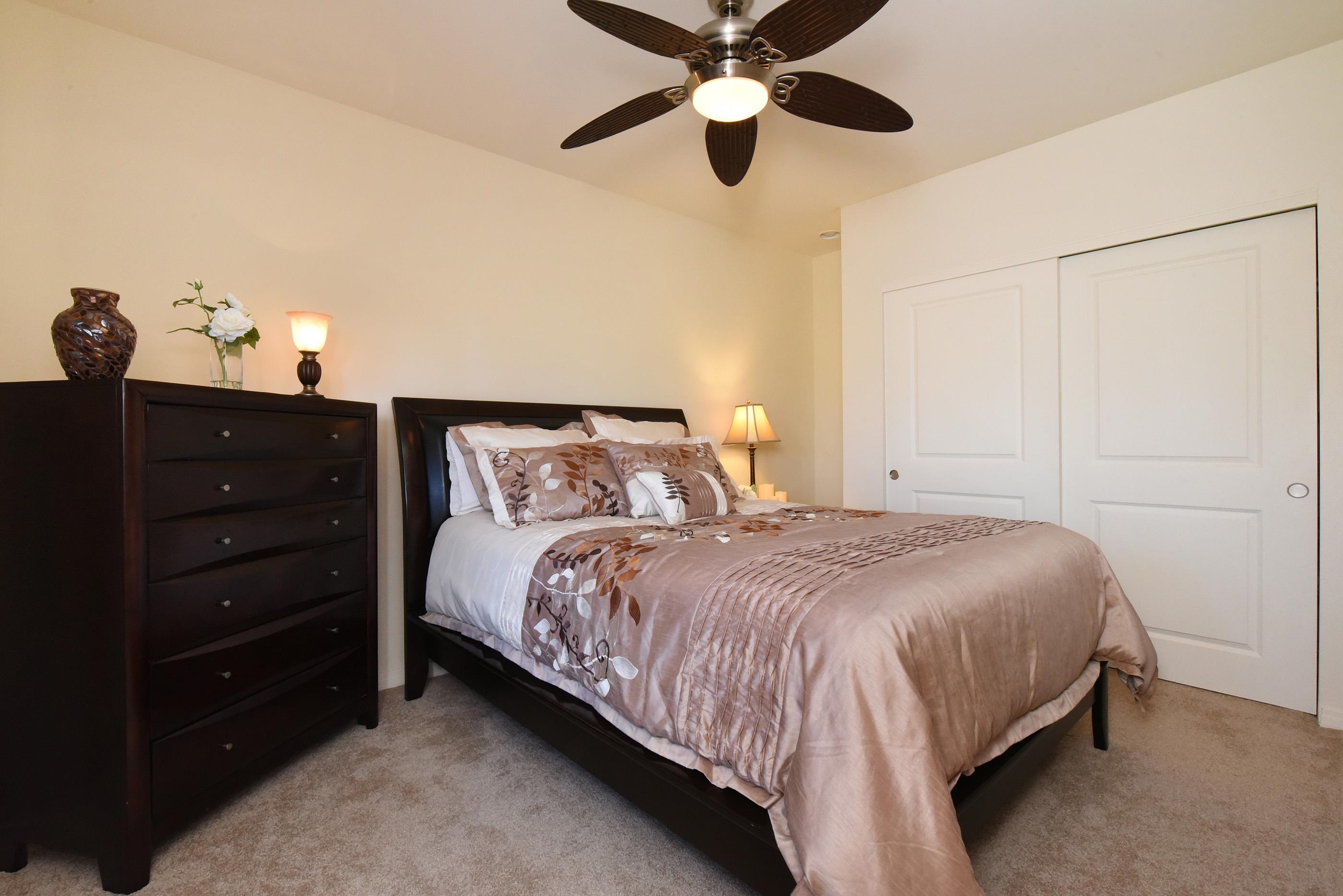 3708 Lower Honoapiilani Road, Unit E30 Lahaina, HI 96761 - Photo 22 of 30 a bedroom with a bed and a chandelier fan