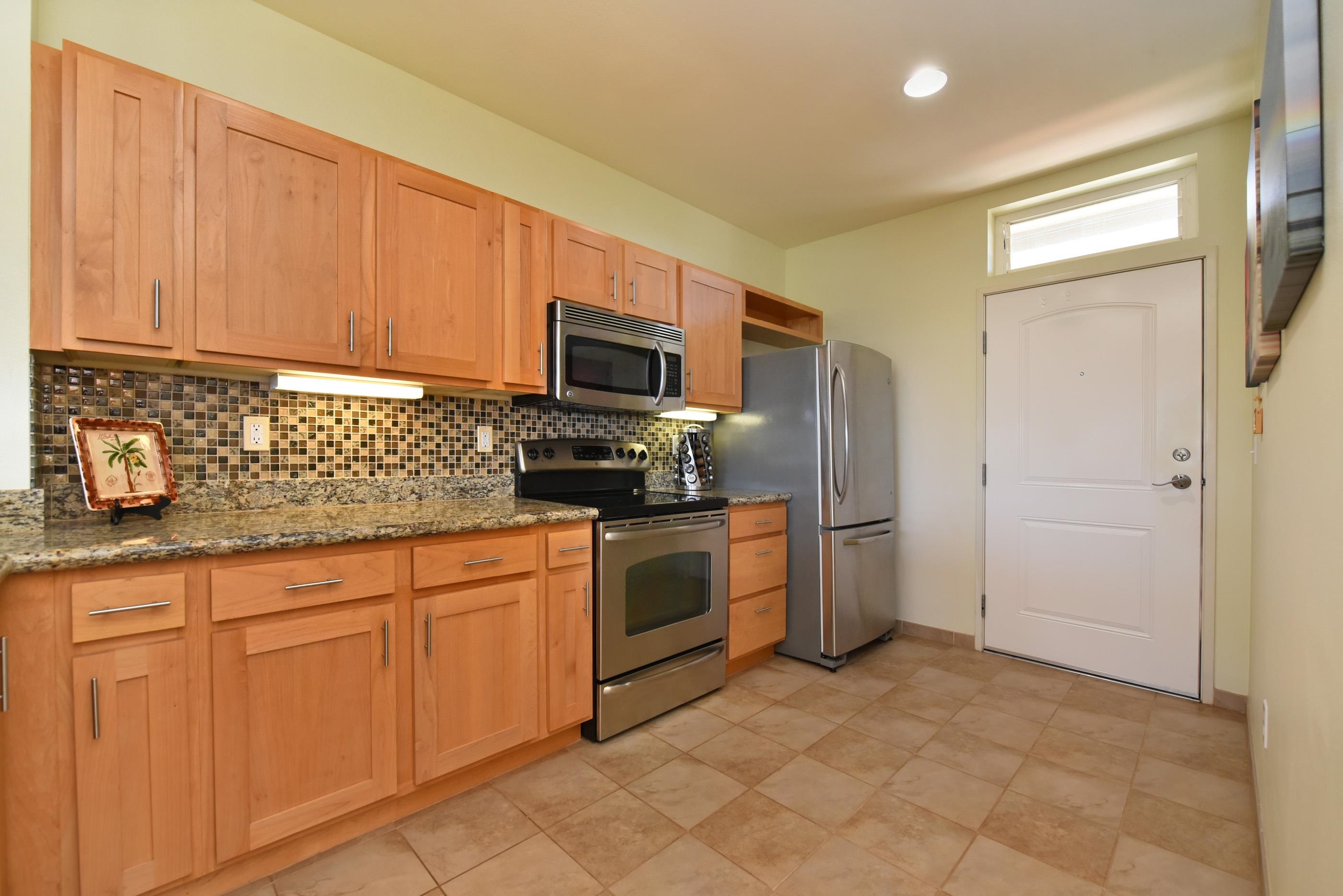 3708 Lower Honoapiilani Road, Unit E30 Lahaina, HI 96761 - Photo 7 of 30 a kitchen with stainless steel appliances granite countertop a refrigerator a stove a sink and dishwasher