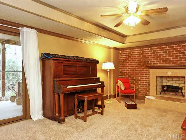 1605 Chatsworth Lane Raleigh, NC 27614 - Photo 12 of 25 Finished area of basement with sliding glass door to patio and gas starter fireplace (no gas logs). There is additional SF in the basement that is plumbed for a full bathroom! Basement