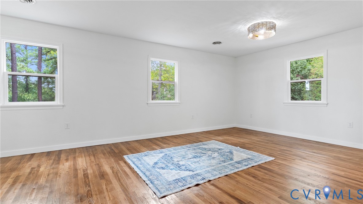 11550 Lunenburg County Road Keysville, VA 23947 - Photo 13 of 48 Hardwood flooring, white walls, three windows, and