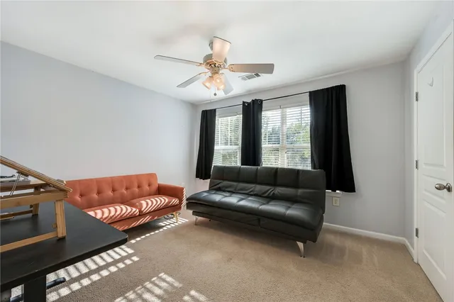 a living room with furniture ceiling fan and a window